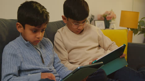 Zwei-Junge-Jungen-Sitzen-Zu-Hause-Auf-Dem-Sofa-Und-Spielen-Spiele-Oder-Streamen-Auf-Digitale-Tablets-7
